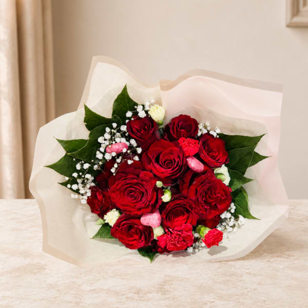 Bouquet of red roses with white filler flowers and pink accents