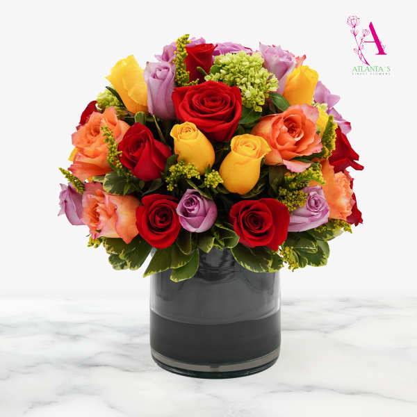 Mixed roses in a dark glass vase with red, yellow, peach, and lavender blooms