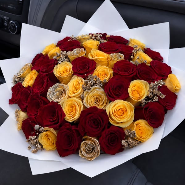 Bouquet of red and yellow roses wrapped in white paper