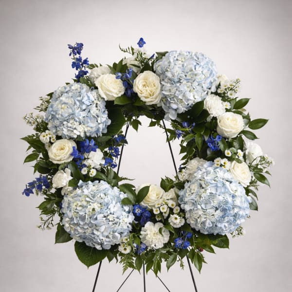 Large blue and white floral wreath on a black stand