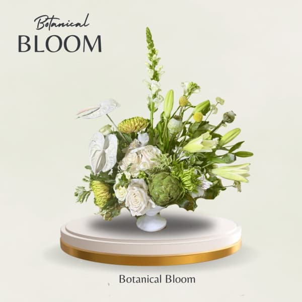 Green and white floral arrangement with lilies and roses in a white vase