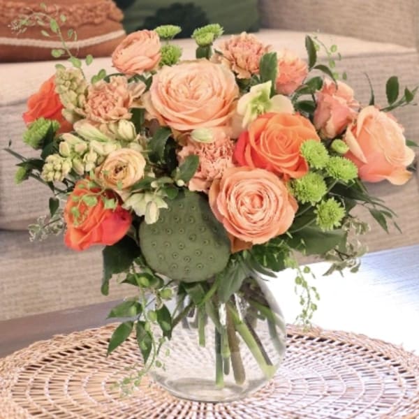 Peach and coral rose bouquet in a clear glass vase