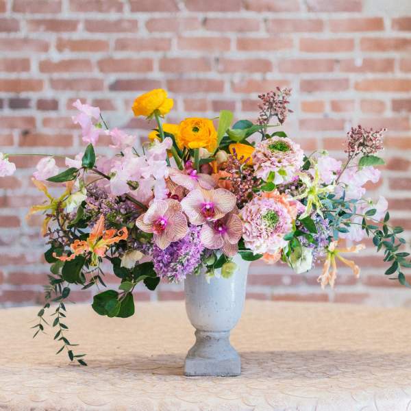 Mixed bouquet in a gray vase with pink, purple, and yellow flowers
