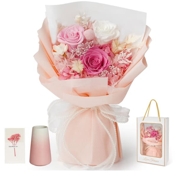 Pink and white rose bouquet wrapped in peach paper with a ribbon