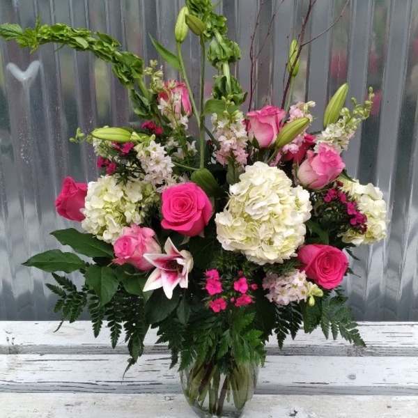 Pink and white mixed flower arrangement in a glass vase