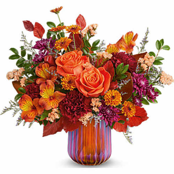 Orange and red mixed bouquet in a striped glass vase