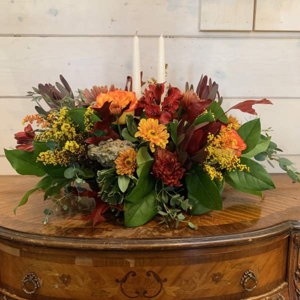 Autumn floral centerpiece with candles in a low arrangement