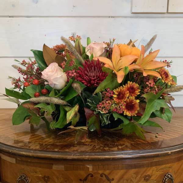 Mixed autumn bouquet with lilies, roses, chrysanthemums, and a small pumpkin