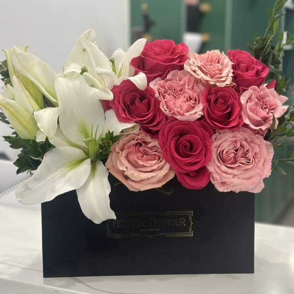 Pink and white roses with white lilies in a black box