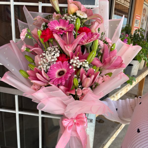 Pink bouquet with lilies, gerbera daisies, and carnations wrapped in pink paper