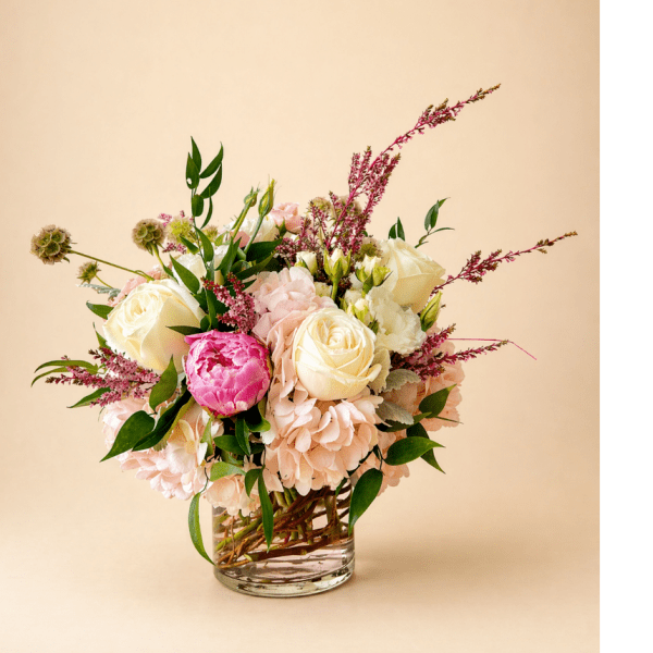 Bouquet of cream and pink roses in a clear glass vase