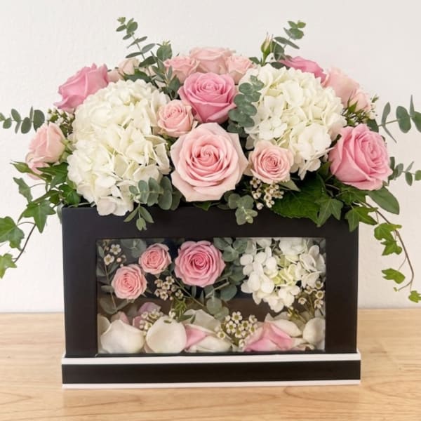 Pink roses and white hydrangeas in a black display box