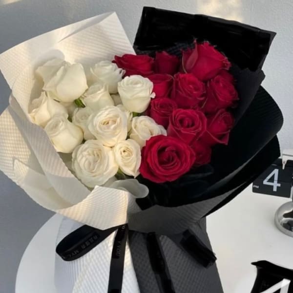 Bouquet of red and white roses wrapped in black and white paper