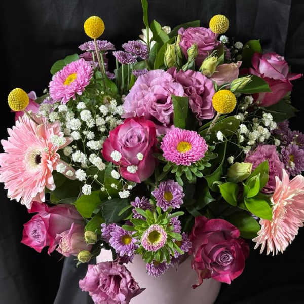 Pink and purple mixed bouquet in a white vase