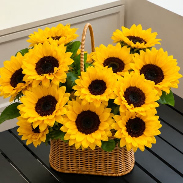 Basket of bright yellow sunflowers with a woven handle