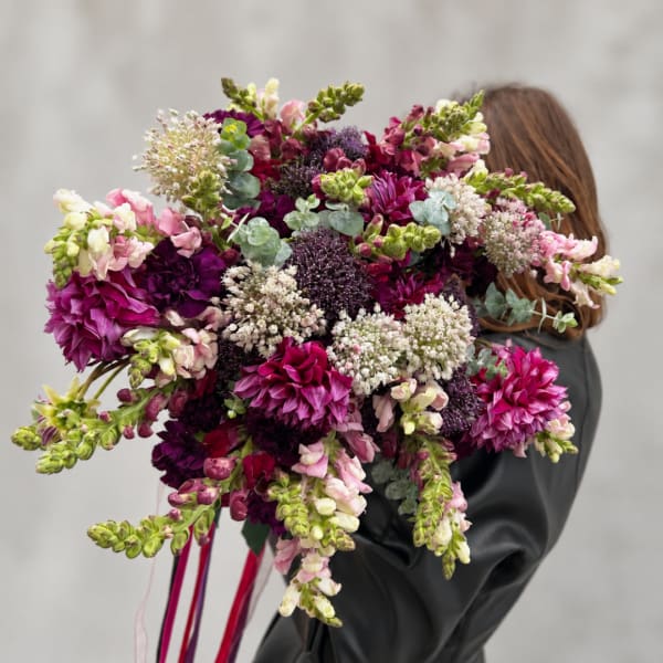 Large bouquet of magenta and white flowers held by a person