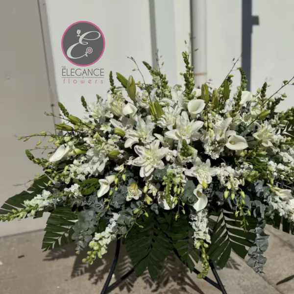 Large white floral spray with calla lilies and lilies on a stand