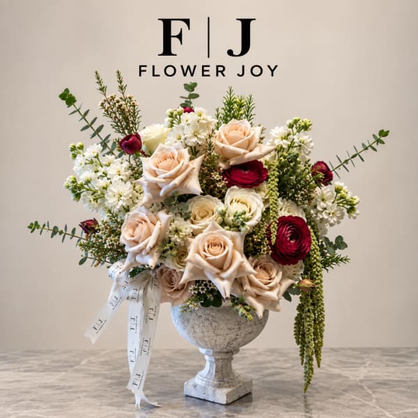 Mixed rose arrangement in a stone pedestal vase with white filler flowers
