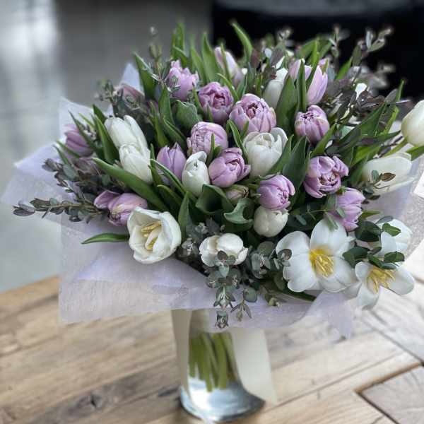 Bouquet of pink and white tulips in a glass vase