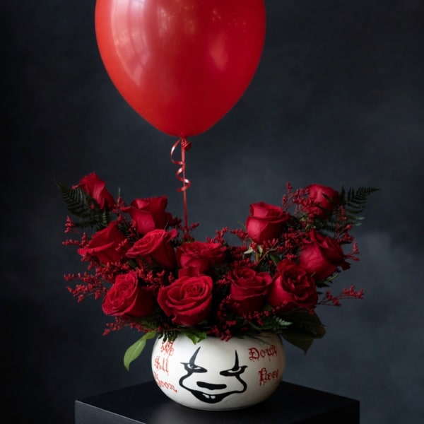 Red rose arrangement in a white painted vase with a red balloon above it
