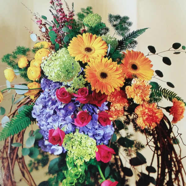 Mixed bouquet with gerbera daisies, roses, hydrangea, and hanging greenery
