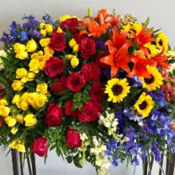 Colorful standing floral spray with roses, lilies, and sunflowers