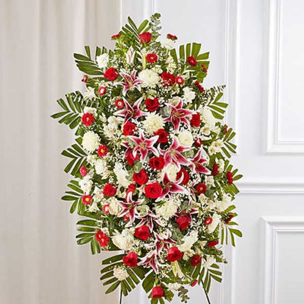Standing floral spray with red and white flowers on a black easel