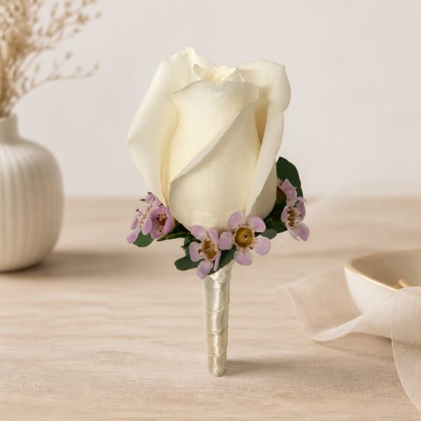 White rose boutonniere with small lavender flowers