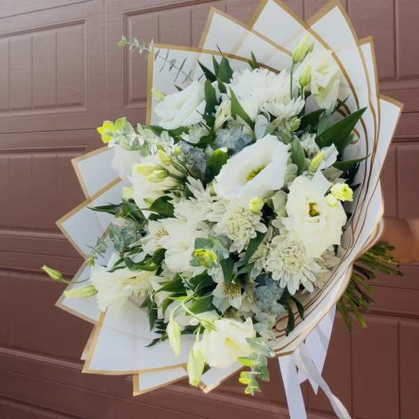 White bouquet with lilies and daisies wrapped in white paper
