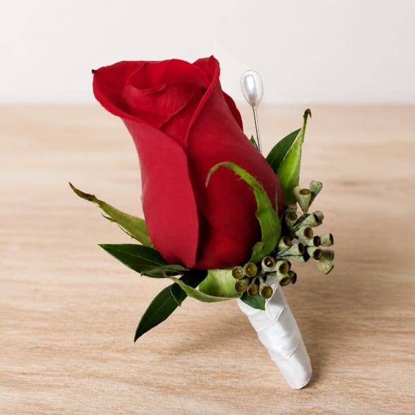 Red rose boutonniere with white ribbon wrap and pearl pin