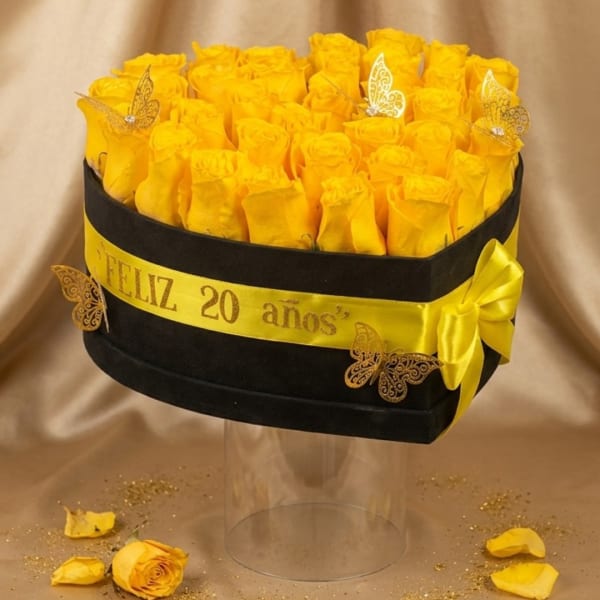 Yellow roses arranged in a black hatbox with a yellow ribbon and butterfly accents
