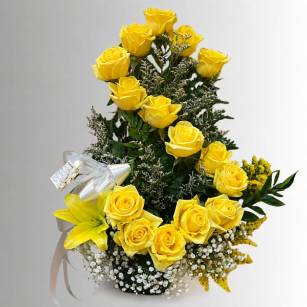 Tall arrangement of yellow roses with a yellow lily in a black container