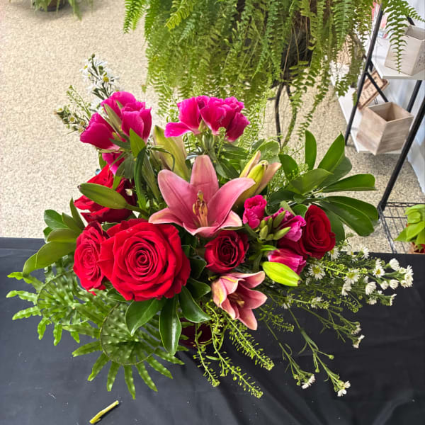 Bouquet of red roses and pink lilies with greenery