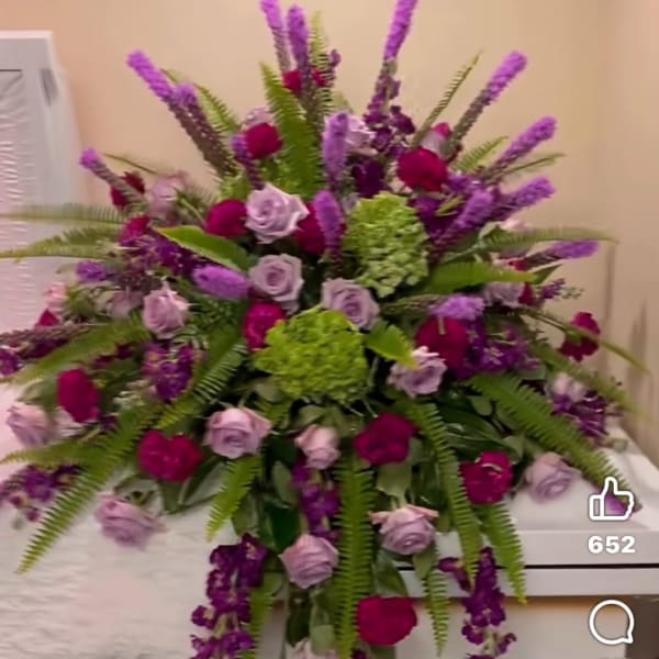 Large bouquet of purple and pink roses with green hydrangeas and fern fronds