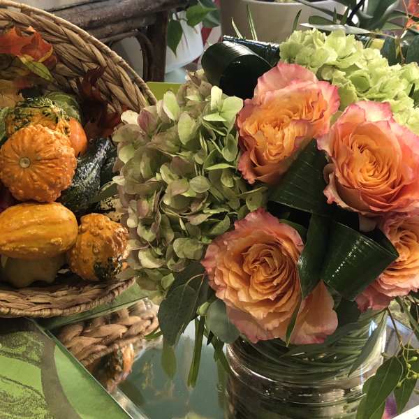 Peach roses and pale green hydrangeas in a glass vase