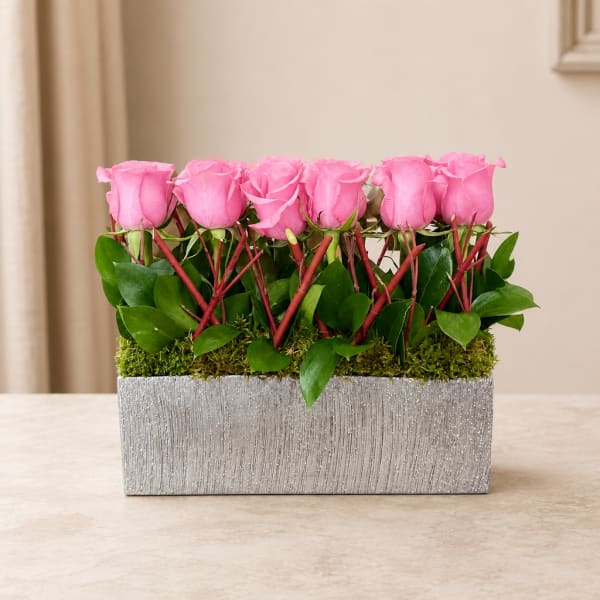 Pink roses arranged in a rectangular silver planter