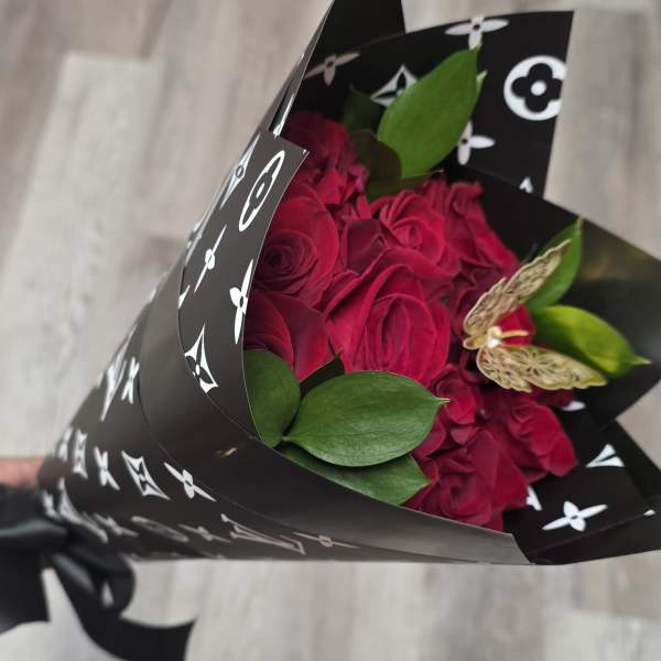Bouquet of deep pink roses wrapped in black patterned paper