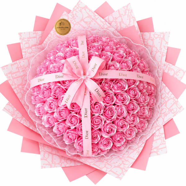 Pink rose bouquet wrapped in patterned paper with a Dior ribbon