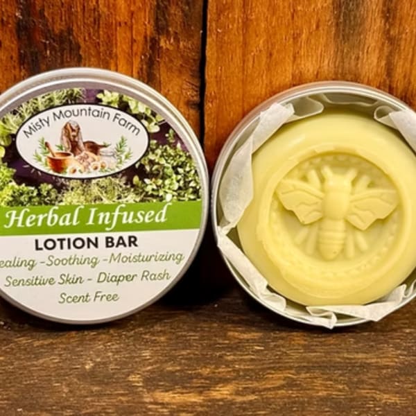 Herbal infused lotion bar in a round tin with a bee design