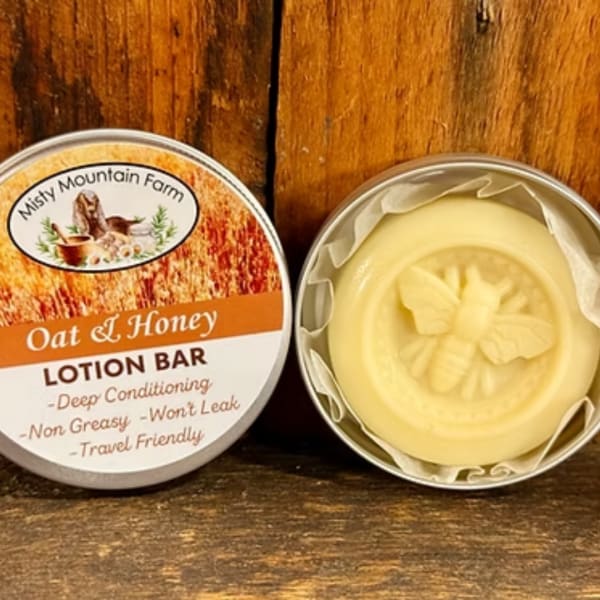 Tin of oat and honey lotion bar beside the opened bar