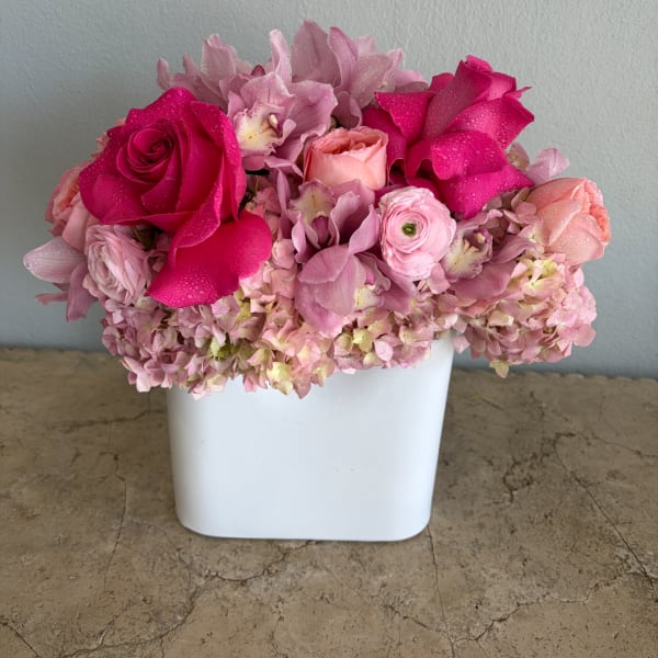Pink and magenta flower arrangement in a white vase