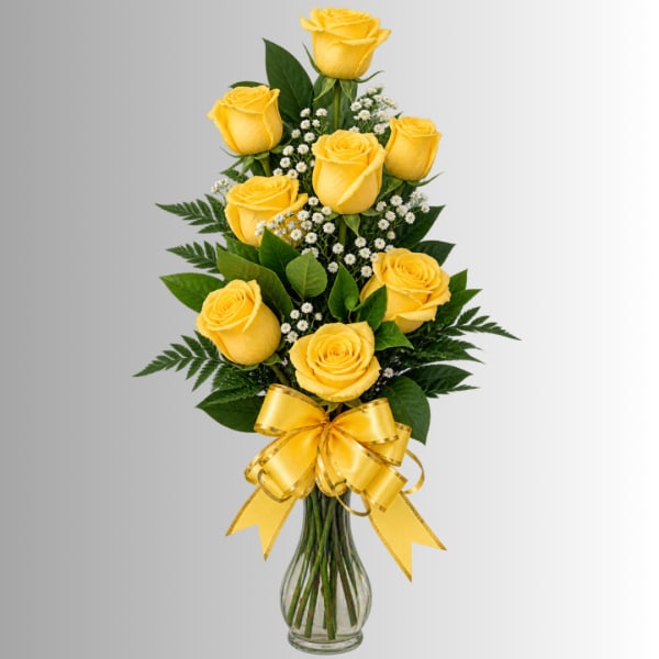Yellow roses arranged in a clear glass vase with a yellow ribbon bow.