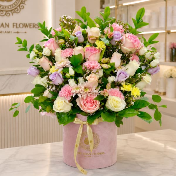 Mixed pastel roses and carnations in a pink hatbox