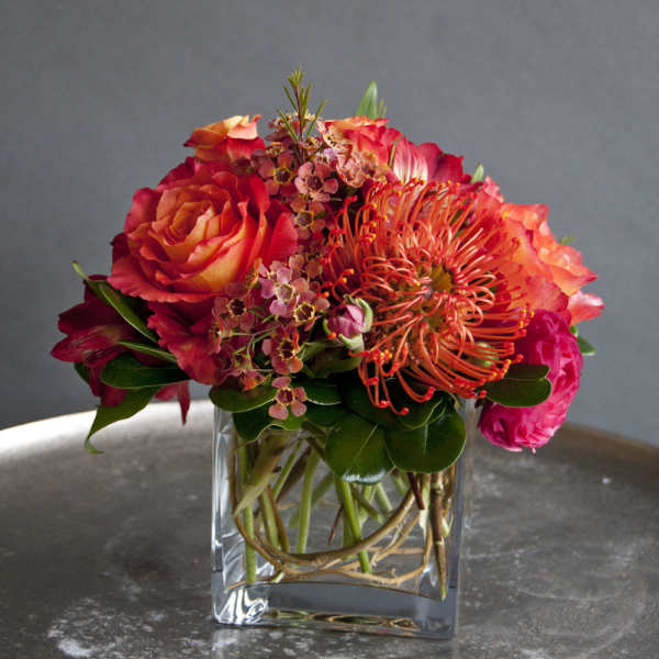 Bouquet of red and orange flowers in a clear glass vase