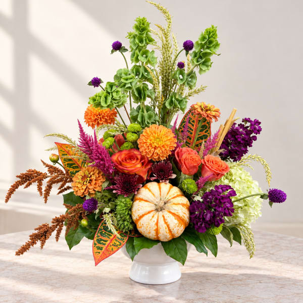 Autumn floral arrangement with a white pumpkin in a white vase