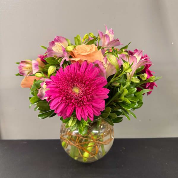 Pink gerbera bouquet with peach roses and alstroemeria in a glass vase
