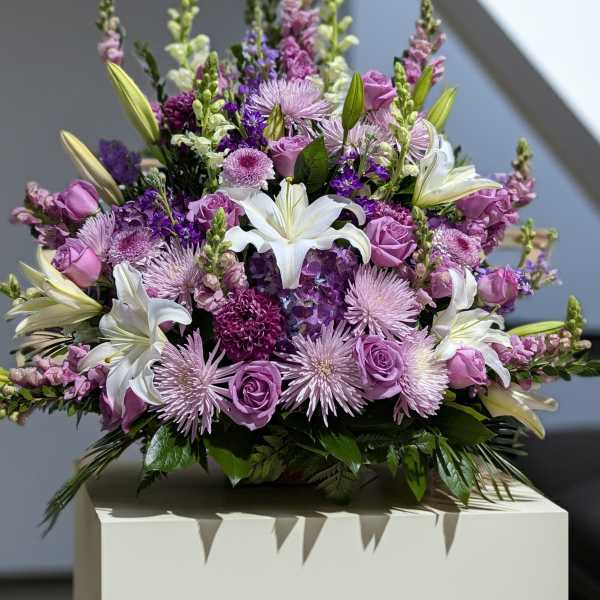 Lavender and white bouquet with lilies and roses in a low arrangement