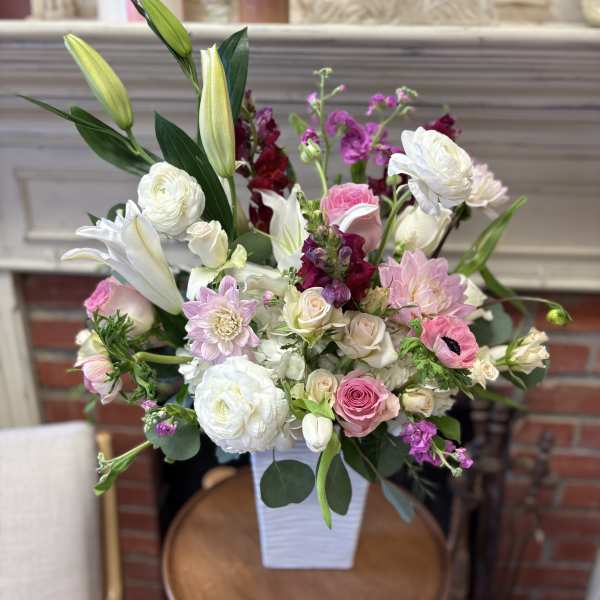 Mixed pink and white flower arrangement in a white vase