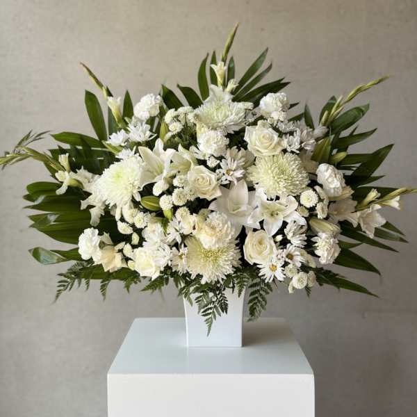 White floral arrangement in a square white vase