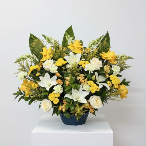 Yellow and white floral arrangement in a dark vase